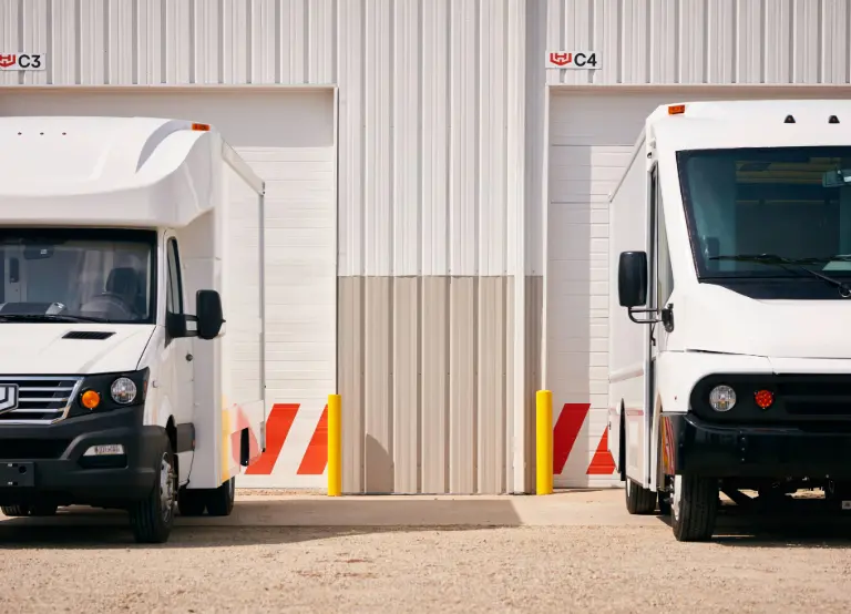 Cropped image of Workhorse electric trucks parked in front of a warehouse building